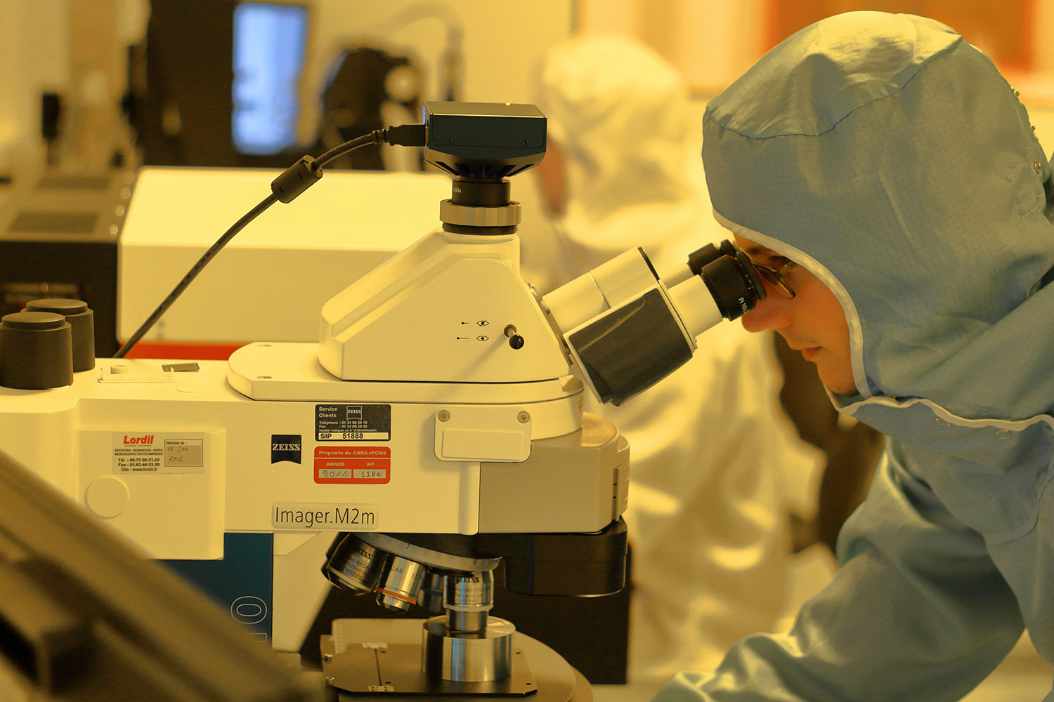Laboratório com homem ao microscópio